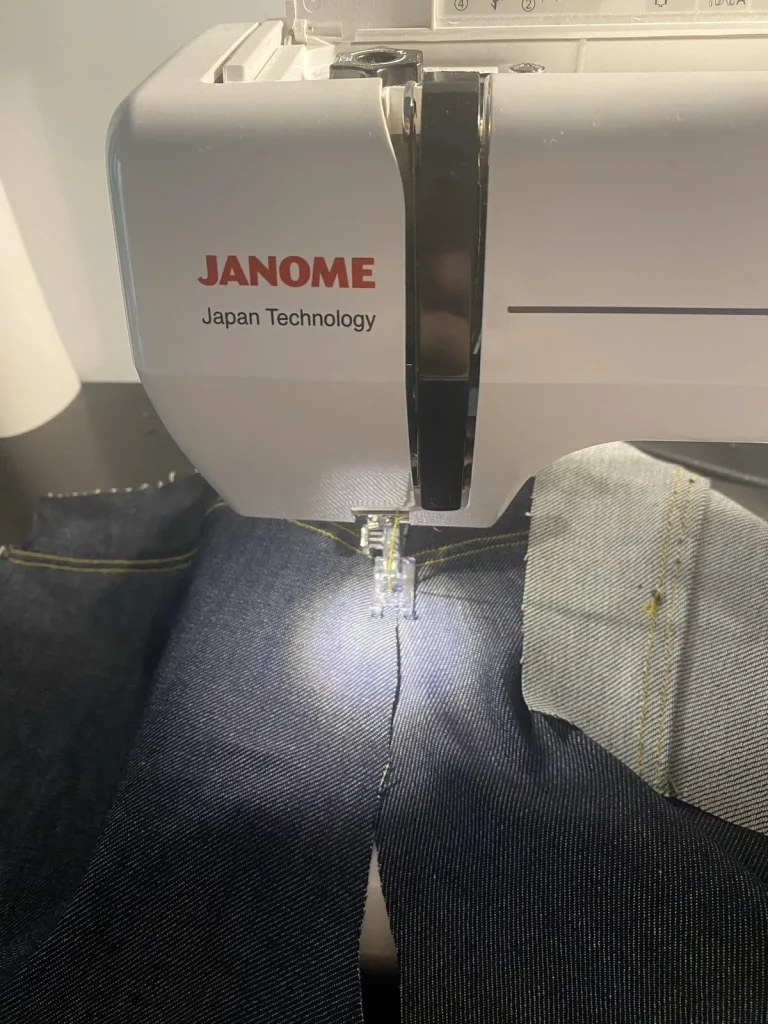 Couture du jean 22BB Timprod : le denim brut sous le pied de la machine à coudre Janome