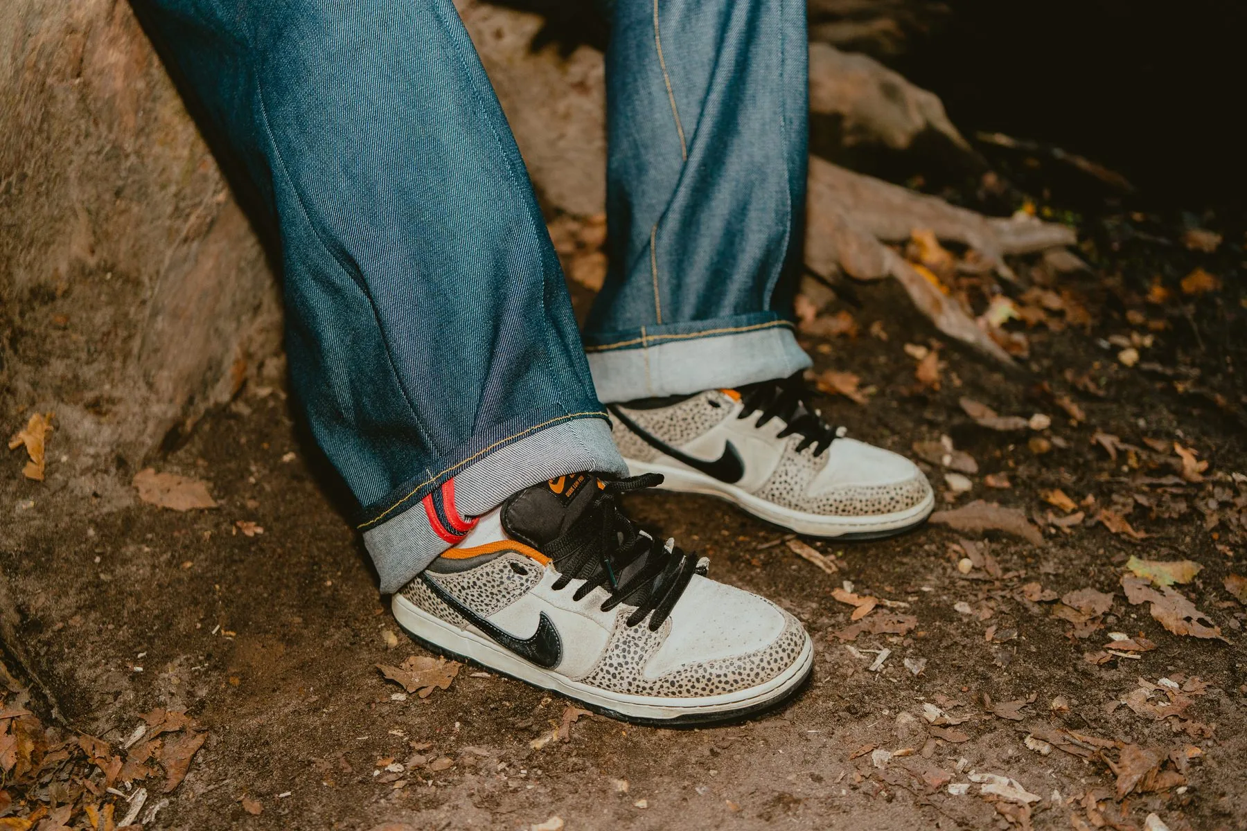 Ourlets retroussés du pantalon baggy 22BB Timprod sur des baskets, pieds posés sur une souche